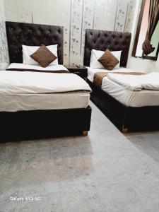 two beds in a room with two bedsskirts at Lord Family Hotel in Lahore