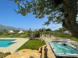 eine Badewanne im Garten neben einem Pool in der Unterkunft Appartamento Limone in Splendida villa Nature al mare di Scopello Zingaro in Scopello
