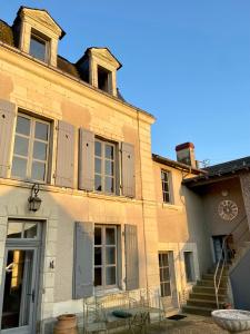 Um edifício antigo com um relógio ao lado. em The Old Winery, Loire em Le Puy-Notre-Dame