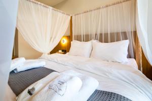 two beds in a bedroom with white sheets and pillows at Denthis Hotel - Taygetos Mountain Getaway in Artemisía