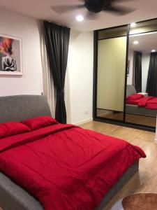1 dormitorio con cama roja y espejo en MyHome Batu Feringghi Penang en Batu Ferringhi