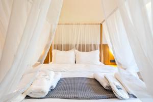 Schlafzimmer mit einem Bett mit weißen Moskitonetzen in der Unterkunft Denthis Hotel - Taygetos Mountain Getaway in Artemisía