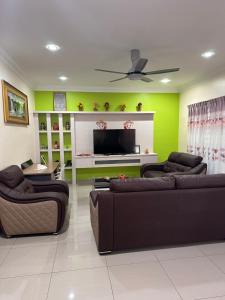 a living room with two couches and a flat screen tv at DOUBLE EE homestay in Sitiawan