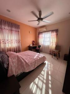 um quarto com uma cama e uma ventoinha de tecto em DOUBLE EE HOMESTAY 6 cars parking place em Sitiawan