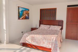a bedroom with a bed and a picture on the wall at Malagana House in Palmira
