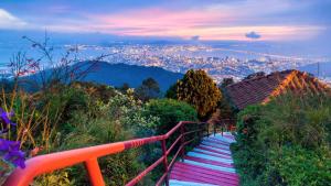 una escalera que sube una colina con una ciudad en el fondo en MyHome Batu Feringghi Penang en Batu Ferringhi