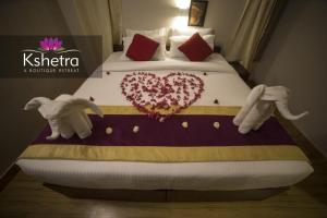een bed met twee gevulde olifanten en een hart erop bij Kshetra Boutique Retreat Varkala in Varkala