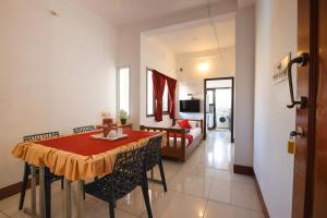 Zimmer mit einem Esstisch und einem Wohnzimmer in der Unterkunft Manora Residency in Puducherry