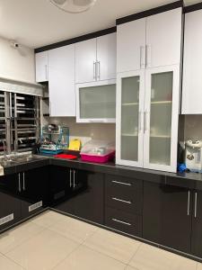 a kitchen with white cabinets and black counter tops at DOUBLE EE HOMESTAY 6 cars parking place 12pax in Sitiawan