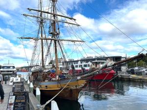 a boat is docked at a dock in the water at Hobart Inner City Apartment in Hobart