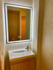 W łazience znajduje się biała umywalka i lustro. w obiekcie F4 Appartement entièrement neuf au cœur de Témara w mieście Temara