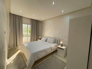 sypialnia z białym łóżkiem i oknem w obiekcie F4 Appartement entièrement neuf au cœur de Témara w mieście Temara