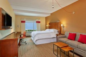 une chambre d'hôtel avec un lit et un canapé dans l'établissement Four Points by Sheraton Dallas Fort Worth Airport North, à Coppell