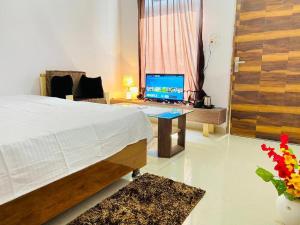 a bedroom with a bed and a desk with a laptop at Green lounge Homestay in Amritsar