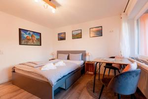 - une chambre avec un lit, un bureau et une table dans l'établissement FeWo Allgäuzeit mit WLAN Oberstaufen Steibis, à Oberstaufen