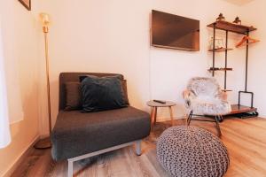 ein Wohnzimmer mit einem Stuhl und einem TV in der Unterkunft FeWo Allgäuzeit mit WLAN Oberstaufen Steibis in Oberstaufen