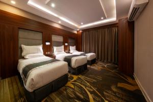 a hotel room with two beds in a room at Msharef Almoden Serviced Apartment in Abha +172 photos