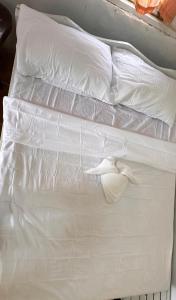a white bed with white sheets and pillows at Private Shawn Guest House in San Vicente