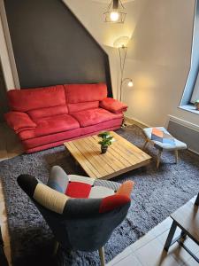 Sala de estar con sofá rojo y mesa de centro en Chambre d'Hôtes calme et cosy, à 3min de la gare, centre ville, avec un lit de 160cm, en Nevers