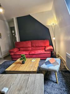 sala de estar con sofá rojo y mesa en Chambre d'Hôtes calme et cosy, à 3min de la gare, centre ville, avec un lit de 160cm, en Nevers