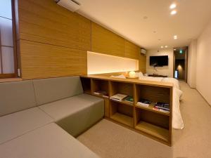 Una sala de estar con un sofá y un televisor. en TokiToki 時時, en Kioto