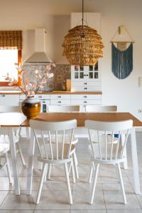 cocina con mesa de madera y sillas blancas en Perivolakia Panorama House, en Perivolákia