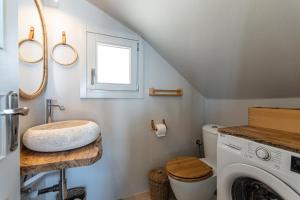 a bathroom with a sink and a washing machine at Helios Selene in Vívlos