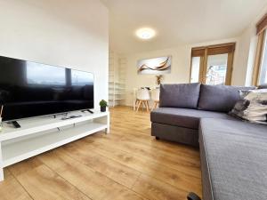 a living room with a couch and a large flat screen tv at King’s Cross & Camden : Stylish Flat in London