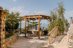 a wooden pergola with a table and chairs under it at Perivolakia Panorama House in Perivolákia