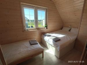 two beds in a room with a window at Plażowisko in Dębki