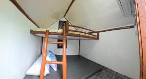 Etagenbett mit Leiter in einem Zimmer in der Unterkunft Kua's Pad Batangas Kubo in Lian