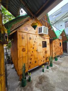 drewniany budynek z roślinami przed nim w obiekcie Kua's Pad Batangas Kubo w mieście Lian
