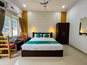 a bedroom with a bed and a desk and a chair at The Yachis Rishikesh in Rishīkesh