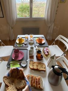 einen Tisch mit Frühstückszutaten auf einem weißen Tisch in der Unterkunft Le Relais des Malettes Chambres d'hôtes B&B in Francheville