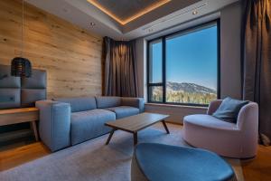 a living room with a couch and a table at DAMIAN JASNA HOTEL RESORT and RESIDENCES in Demanovska Dolina