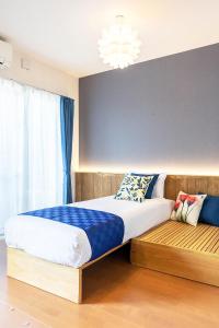 - une chambre avec un lit et un banc en bois dans l'établissement Chura Minpaku Ishigaki, à Ishigaki