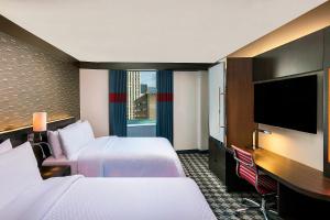 a hotel room with two beds and a flat screen tv at Four Points by Sheraton New York Downtown in New York