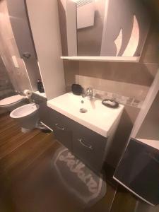 uma casa de banho com um lavatório, um WC e um espelho. em IL NIDO Suite em Fiuggi