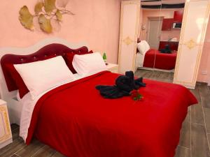 una camera da letto con un letto rosso e un orsacchiotto nero sopra di IL NIDO Suite a Fiuggi
