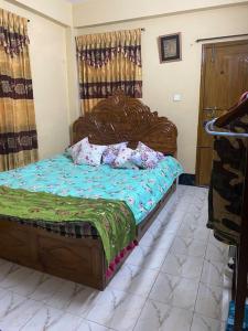 1 dormitorio con cama de madera y almohadas en Holiday Home in Khastobir Sylhet Town, en Sylhet
