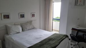 - une chambre avec un lit, un bureau et une fenêtre dans l'établissement Atlantic City Apart, à Salvador