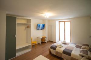 1 dormitorio con cama, escritorio y ventana en La Lesivèra Bed and Breakfast, en Tione di Trento