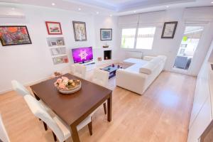 a living room with a table and white chairs at Anna & Thomas - Sitges Center Apt in Sitges