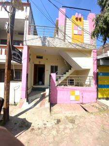 een roze en geel huis met een hek bij Sahu Home stay in Ujjain