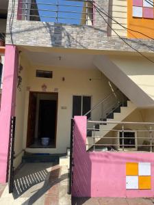 een gebouw met een trap en een roze muur bij Sahu Home stay in Ujjain
