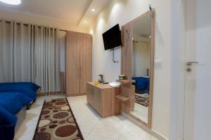 uma sala de estar com um sofá azul e um espelho em Hotel Restorant Halal Il Tramonto. em Vorë