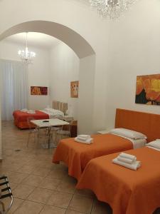 a room with two beds and a table with chairs at Casa Sorrentina in Sorrento
