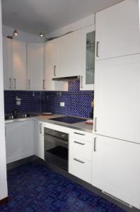 een keuken met witte kasten en een fornuis bij Homely flat for 4 guests in Porto Santa Margherita di Caorle