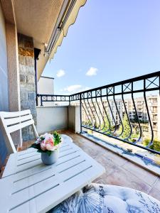 a white bench on a balcony with a view at Апартамент Каскадас В54 in Sunny Beach