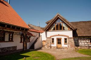une maison blanche avec un toit orange dans l'établissement Hotel Głęboczek Vine Resort& Spa, à Wielki Głęboczek